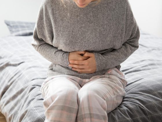 Femeie tânără ținându-și abdomenul din cauza durerilor menstruale asociate cu endometrioza